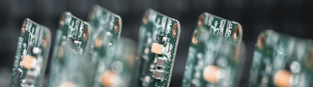 SMD‑bestückte Leiterplatte, die neben mehreren weiteren bestückten Karten steht