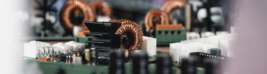 Nahaufnahme einer THT‑bestückten Leiterplatte mit klar erkennbaren bedrahteten Bauteilen