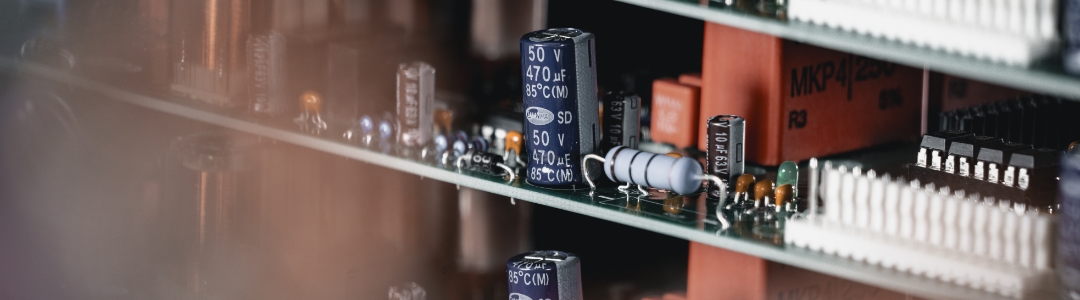 Detailaufnahme einer THT‑bestückten Leiterkarte mit bedrahteten Bauteilen