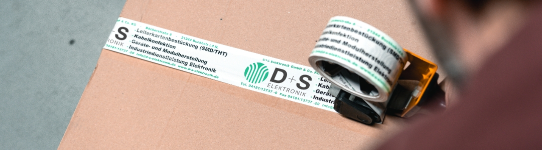 Klebeband wird auf ein Paket abgerollt als Symbol für Logistik und Versandprozesse