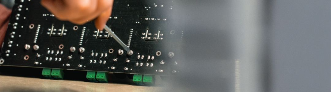 Schraube wird von der Rückseite angezogen, um ein Bauteil in der Gerätemontage zu fixieren