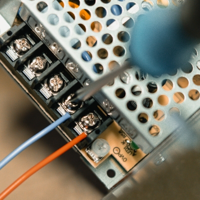 Kabelmontage in der Elektronikfertigung Kabel wird mit einem Schraubenzieher festgezogen als Teil der Gerätemontage