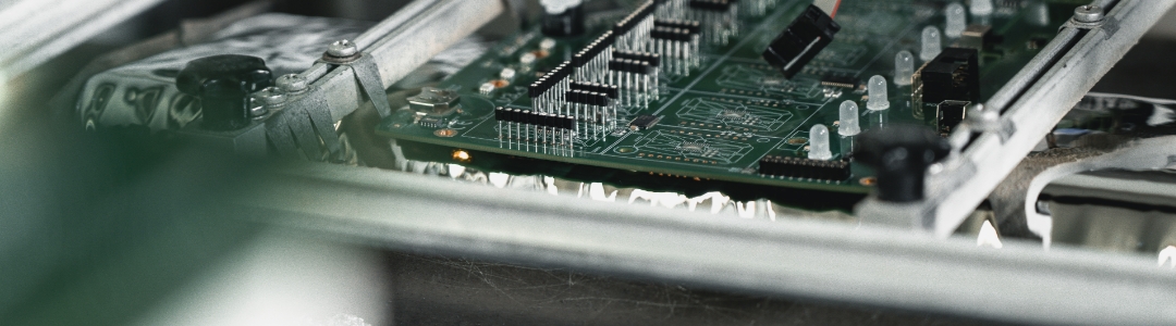 Leiterplatte wird im Wellenlötverfahren durch die Lötwelle geführt